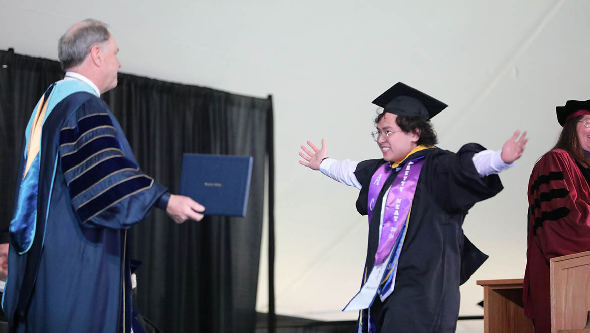 Hartwick graduate wling across Commencement stage