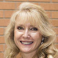 Tina Dalrymple Headshot of a smiling woman with blonde, wavy hair.
