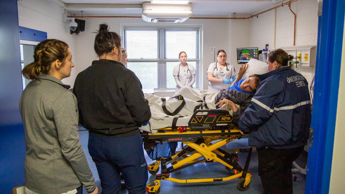 Hartwick nursing students wtih EMS personel treating emergency response drill patient