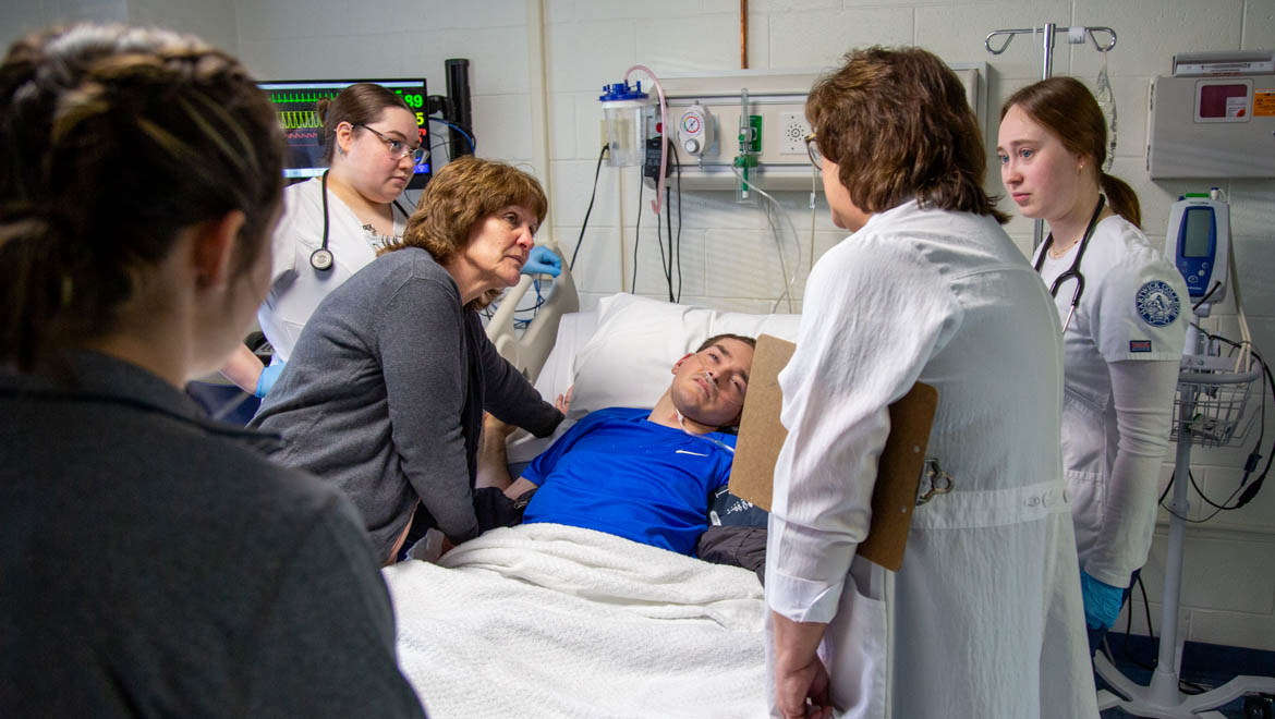 Hartwick nursing students and Hartwick School of Nursing Clinical Assistant Professor Lisa Depperman treating emergency response drill patient