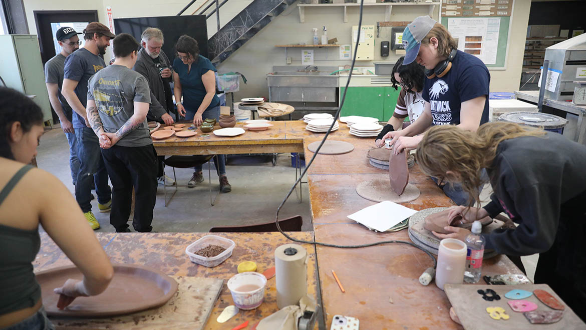 Hartwick ceramics students, Professor Stephanie Rozene and Oneonta’s Autumn Café team in ceramics studio with dinnerware