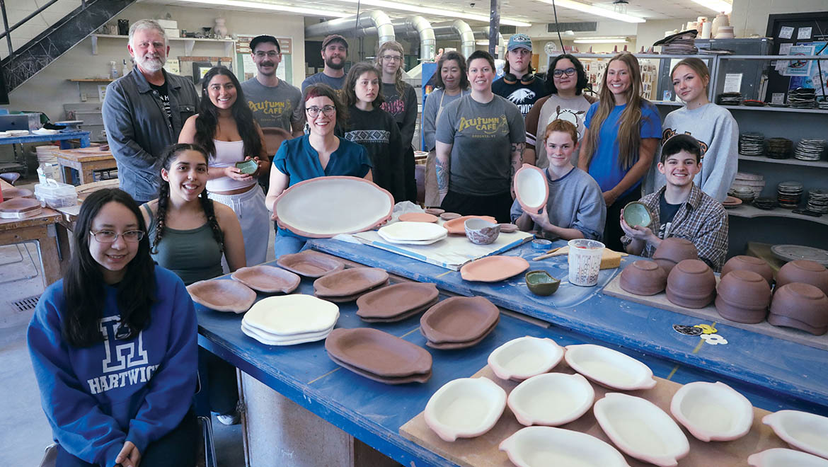 Hartwick ceramics students, Professor Stephanie Rozene and Oneonta’s Autumn Café team in ceramics studio with dinnerware