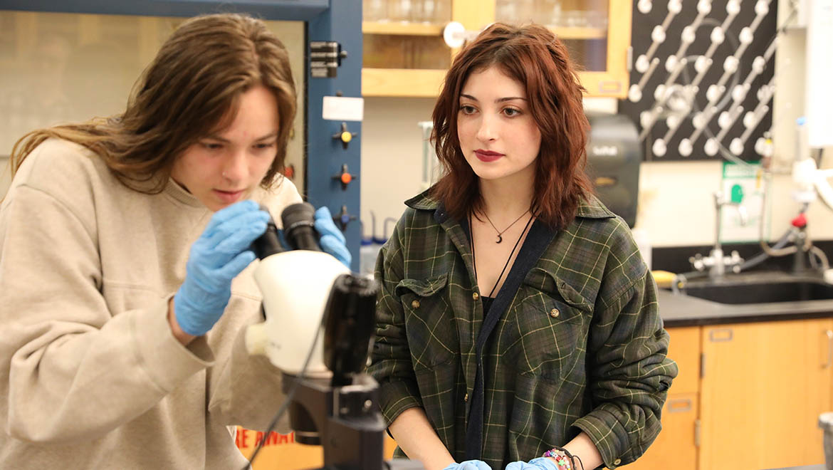 Hartwick College students in lab using microscope