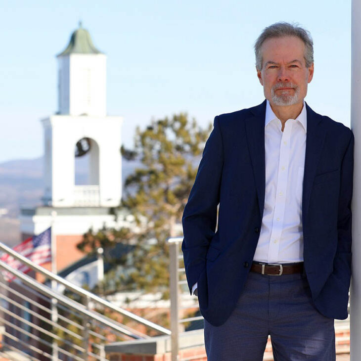 Portrait of Three-time Pulitzer Prize-winning New York Times investigative reporter and Hartwick alumnus Mike McIntire '85 on Hartwick campus with Yager Bell Tower in the background