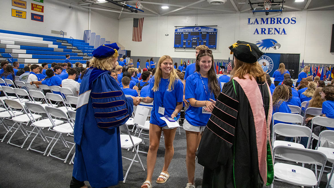 Hartwick College President Bongiorno and VP for Academic Affairs & Provost Deardin greet new students in blue t-shirts at Opening Convocation
