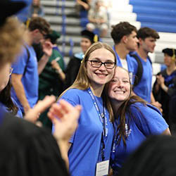 Two smiling new students in Hartwick College blue t-shirts during Opening Convocation
