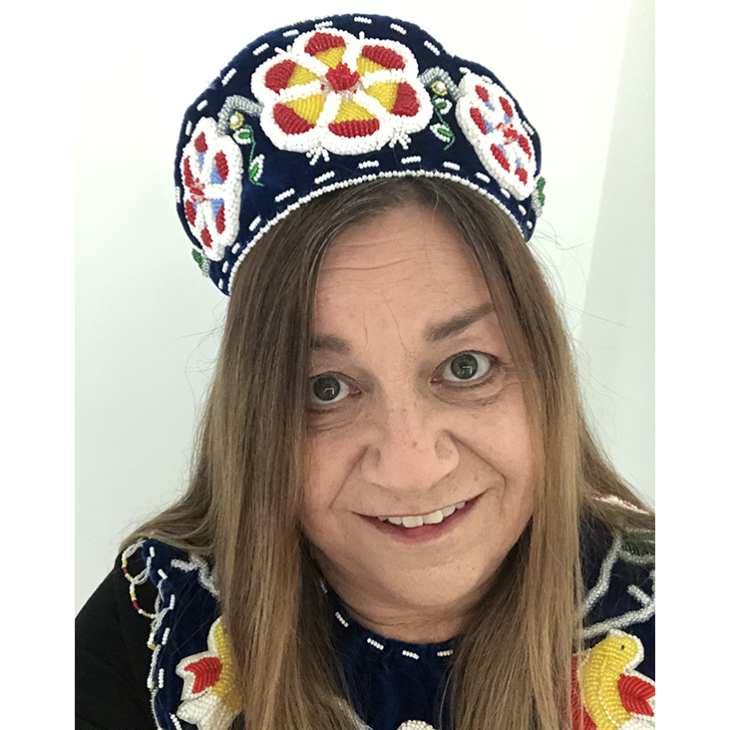 Portrait of Melanie Printup Hope wearing a headpiece adorned with intricate beadwork