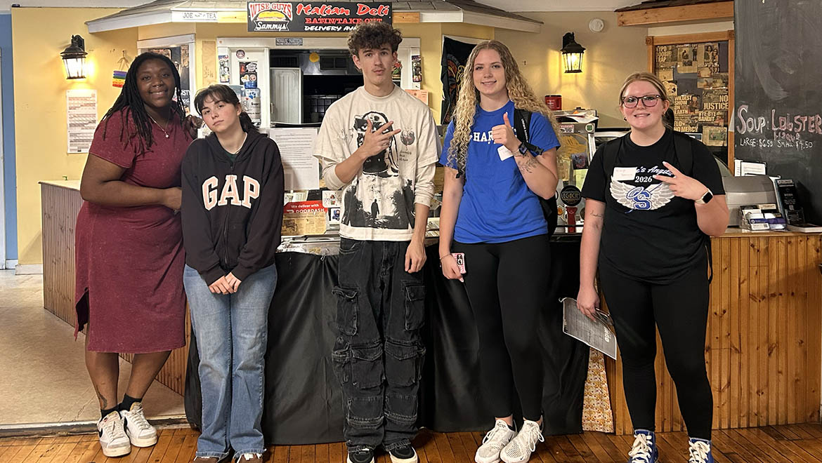 Hartwick College Thrive students and program coordinator stand in a line in front of a deli counter.